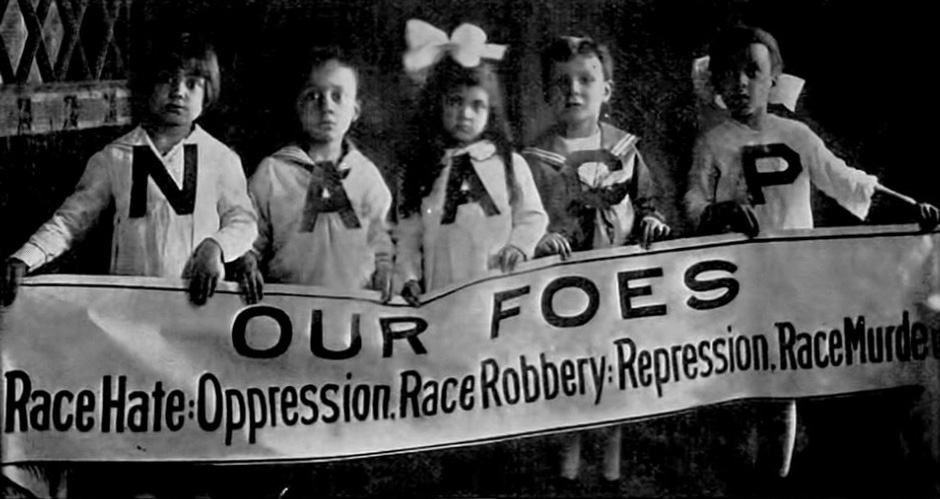 Girls holding anti-racism sign.